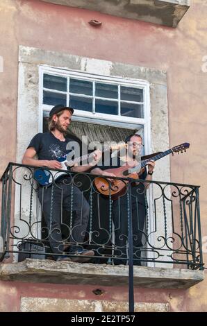 Musiker spielen Gitarre auf Balkon in der Rua de Santa Cruz do Castelo, Castelo Nachbarschaft, Lissabon, Portugal Stockfoto