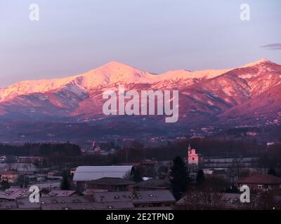 Profil einer Piemontesischen Alp mit Blick auf die Po-Ebene eingetaucht In einem rosa Sonnenuntergang Stockfoto