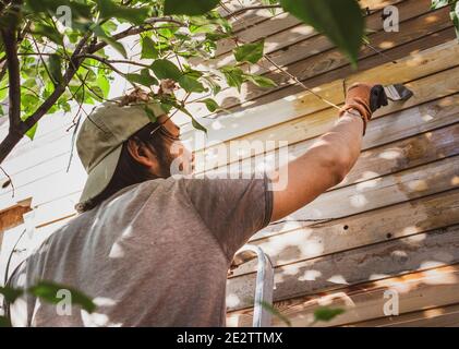 Mann Malerei Holzwand des Hauses im Freien Stockfoto