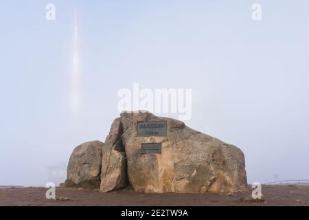 Gipfelstein des Brockens im Nationalpark Harz, Sachsen-Anhalt, Deutschland. Der höchste Gipfel des Harzes ist mit Nebel bedeckt. Stockfoto