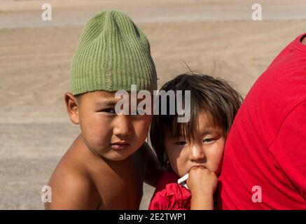 Olgii, Mongolei - 7. August 2019: Familie auf dem Motorrad mit zwei kleinen Kindern in der Steppe der Mongolei. Stockfoto