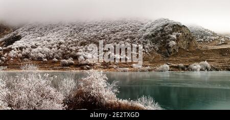 Erdbeobachtung, Zeit vor dem Winter. Der Winter ist von den Bergen zu den Ausläufern herabgestiegen. Frost überzogen Bäume, Sträucher und Gräser, gefrorene Gewässer Stockfoto