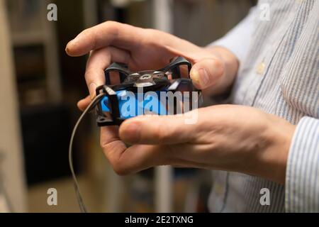 Kühler, Lüfter vom Computer mit geöffnetem Lager zur Reparatur und Schmierung in den Händen des Servicemitters Stockfoto