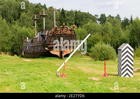 Antike Verkehrskontrollposten mit Barriere und altes Piratenschiff Im Wald Stockfoto