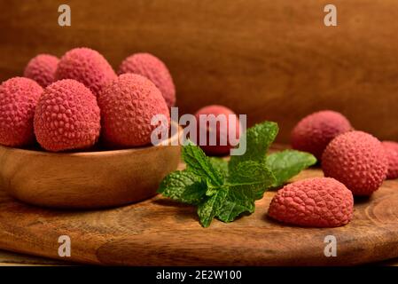 Bunte natürliche Bio-Lychees in einer Holzschale Stockfoto