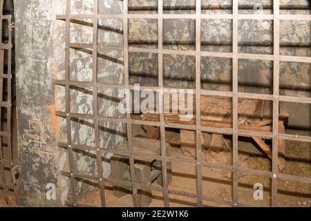 Antike Gefängniszelle mit Bars und Etagenbetten Stockfoto