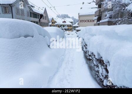 Sankt Gallen, Schweiz - 15. Januar 2021: Geparkte Autos im Schnee begraben Stockfoto