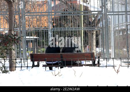 Madrid, Spanien, 15/01/2021.- zwei Jugendliche plaudern in einem noch verschneiten Park.EINE Woche nach dem Sturm Filomena und Schneefall sind die Straßen immer noch mit Schutt und Eisschilden überflutet.die Folgen werden noch tagelang andauern. Der erste, der sowohl für den Anblick als auch für den Geruch spürbar ist, ist der Müll, der sich in vielen Straßen der Hauptstadt ansammelt. Der Bürgermeister von Madrid, José Luis Martínez-Almeida, versicherte, dass "alle Erwartungen mit der Sammlung von 1,100 Tonnen Müll aus den Straßen der Hauptstadt übertroffen wurden". "100% der Müllsammelfahrzeuge der Stadt sind im Umlauf" und dass "mehr Tonnen werden c Stockfoto