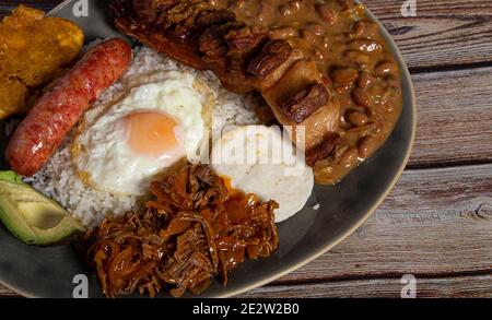 Bandeja Paisa, typisches Gericht Kolumbiens. Es besteht aus chicharrón (gebratener Schweinebauch), schwarzem Pudding, Wurst, Arapa, Bohnen, gebratene Banane, Avocado-Ei Stockfoto