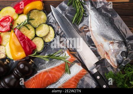 Produkte in Vakuumverpackung, auf einem Holzbrett. Gemüse, Fischfleisch, Dolma, Kurza. Quarantäne-Pandemie Stockfoto
