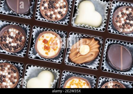 Verschiedene Schokoladenpralinen. Schachtel mit belgischen Pralinen in verschiedenen Formen. Auswahl an feinen belgischen weißen, dunklen und milchfarbenen Pralinen Stockfoto
