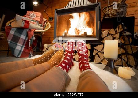 Paar liegen am Kamin für die New dekoriert Jahre Urlaub im gemütlichen Haus Interieur Stockfoto