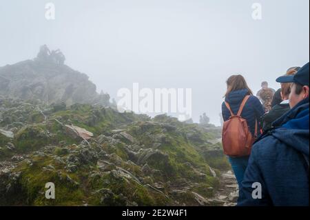 Snowdon, Großbritannien. 08/07/2020. Lockere Pandemiesperrregeln führten zu einer Zunahme von „tay-cations“. Touristen in der Warteschlange für ihre Reihe zu Peak für Selfie zugreifen. Stockfoto