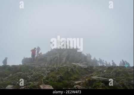 Snowdon, Großbritannien. 08/07/2020. Lockere Pandemiesperrregeln führten zu einer Zunahme von „tay-cations“. Touristen in der Warteschlange für ihre Reihe zu Peak für Selfie zugreifen. Stockfoto