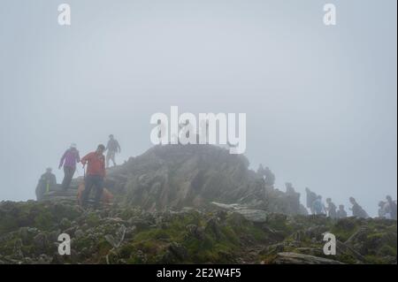 Snowdon, Großbritannien. 08/07/2020. Lockere Pandemiesperrregeln führten zu einer Zunahme von „tay-cations“. Touristen in der Warteschlange für ihre Reihe zu Peak für Selfie zugreifen. Stockfoto