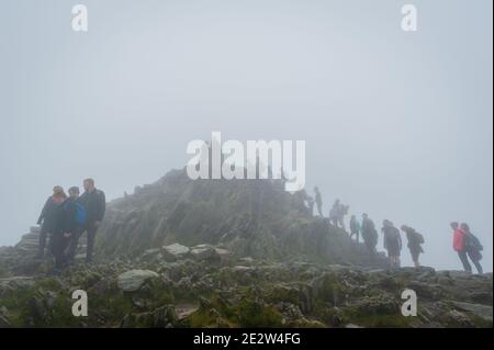 Snowdon, Großbritannien. 08/07/2020. Lockere Pandemiesperrregeln führten zu einer Zunahme von „tay-cations“. Touristen in der Warteschlange für ihre Reihe zu Peak für Selfie zugreifen. Stockfoto