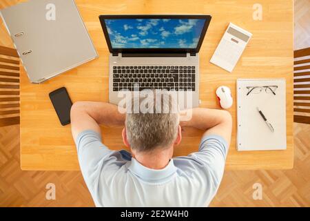 Müde Mann schläft an einem Tisch mit Laptop während der Arbeit Von zu Hause aus - Blick von oben - konzentrieren Sie sich auf die Tastatur Stockfoto