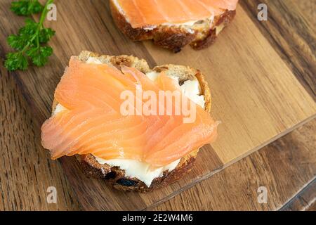 Lachsbraten mit Frischkäse auf dem Feigenbrot, gesundes Essen und Fisch-Sandwich-Konzept. Draufsicht Stockfoto