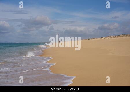 Fischer fischen auf einem leeren Comporta Strand mit Meereswellen Auf dem Sand in Portugal Stockfoto