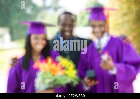 Verschwommenes Foto von Vater mit Tochter und Sohn in der Abschlussfeier Zeremonie Stockfoto