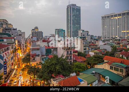 Luftaufnahme über das geschäftige Stadtzentrum von Hanoi mit Hochhäusern, Wohnungen und Verkehr bei Sonnenuntergang, Vietnam Stockfoto