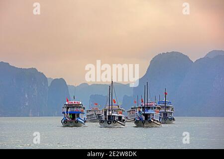 Touristische Boote und Kalkstein monolithischen Inseln in Ha Long Bay / Halong Bay / Vinh Ha Long, Quang Ninh Provinz, Vietnam Stockfoto
