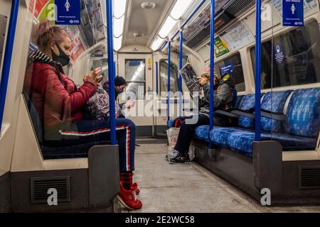 London, Großbritannien. Januar 2021. Eine der Schlagzeilen der Zeitung ist zu Hause bleiben, aber seine hat den Leser vorbei - die U-Bahn ist immer noch ziemlich beschäftigt trotz der neuen nationalen Lockdown, Aufenthalt zu Hause, Anweisungen. Die meisten Reisenden tragen Masken, da sie bereits obligatorisch sind. Kredit: Guy Bell/Alamy Live Nachrichten Stockfoto