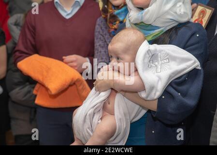 Ein kleines Kind in einer Kirche am Ritus der Taufe. Stockfoto