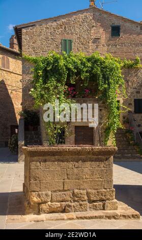 Ein Brunnen an einem historischen Platz im Zentrum der mittelalterlichen Stadt Monticchiello in der Nähe von Pienza in der Provinz Siena, Toskana, Italien Stockfoto