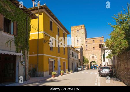 Eine Straße im mittelalterlichen Dorf Paganico in der Nähe von Civitella Paganico in der Provinz Grosseto, Toskana, Italien.ein Teil der Stadtmauer ist im Hintergrund Stockfoto