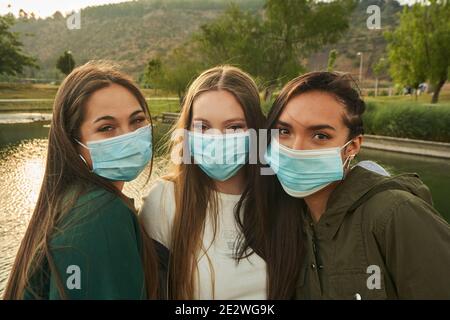 Eine Gruppe von schönen jungen Freunden posiert und trägt Gesicht Masken in einem Stockfoto