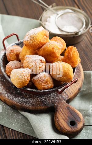 Kleine Donuts. Hausgemachte Quark gebratene Kekse in Fett und bestreut mit Puderzucker in einem Vintage-Teller auf einem hellen Hintergrund. Selektiver Fokus. Stockfoto