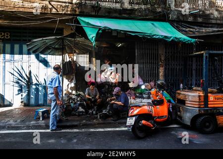Man Watches Mechaniker arbeiten an Autoteilen in Talat Noi in Bangkok Stockfoto