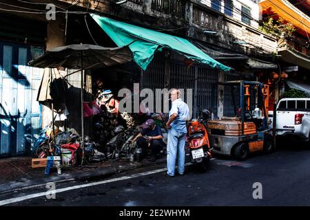 Man Watches Mechaniker arbeiten an Autoteilen in Talat Noi in Bangkok Stockfoto