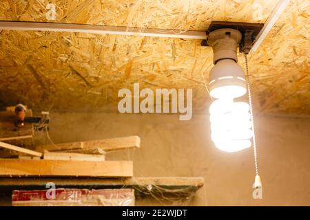 Alte Glühbirne an einer Holzdecke Stockfoto