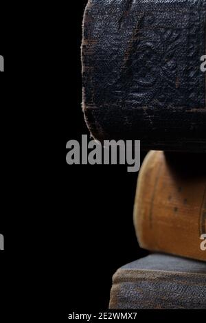 Alte Bücher mit abgenutzten Hardcover isoliert auf schwarzem Hintergrund. Stockfoto