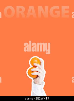Hand hält zwei Orangen und das Wort Orange auf einem hellen orange Hintergrund, Collage im Magazin-Stil Stockfoto