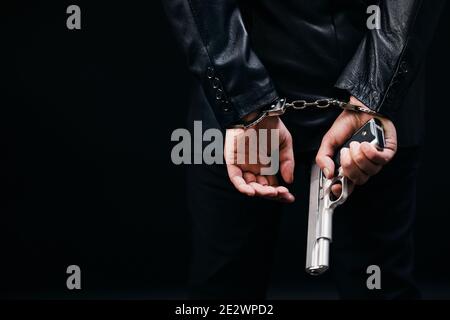 Gangster in Handschellen mit echter Waffe Stockfoto