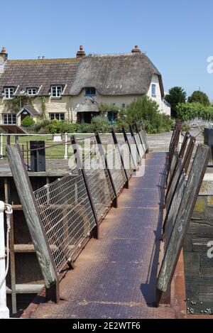 Porlock Weir Bridge über den Schleusen, mit Gibraltar Cottage im Hintergrund Stockfoto