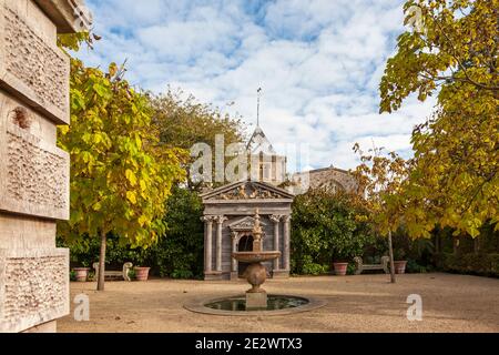 Eleganter Brunnen und Holztempel im Colllector Earl's Garden, mit dem Turm der St. Nicholas Pfarrkirche dahinter, Arundel Castle Gardens, West S Stockfoto