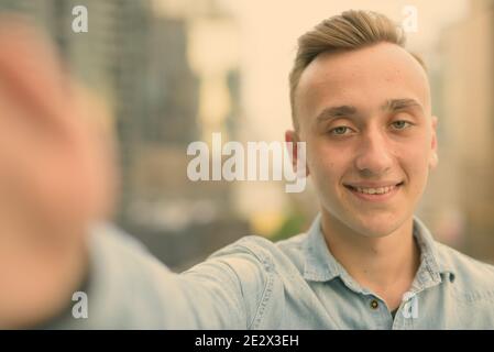 Junger stattlicher Mann mit blonden Haaren gegen den Blick auf die Stadt Stockfoto