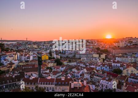 Sonnenuntergang von Miradouro da Senhora do Monte, Lissabon, Portugal. Ein atemberaubender Blick über die gesamte Stadt und Skyline, mit einem klaren, wolkenlosen Himmel. Stockfoto