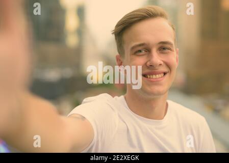 Junger stattlicher Mann mit blonden Haaren gegen den Blick auf die Stadt Stockfoto