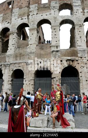 Exklusiv. Schauspieler in römischen Soldatenkostümen stellen am 2010. Juni eine Vorstellung auf, während Touristen vor dem Kolosseum in Rom, Italien, Fotos machen. Roms Kolosseum, bald seine Arena zu öffnen, unterirdisch und höchste Ebene nach umfangreichen Restaurierung. Zum ersten Mal können Touristen den Untergrund besuchen, wo einst Gladiatoren für Kämpfe vorbereitet wurden und Löwen und Tiger eingekerkt wurden, bevor sie ein blutrünstiges Publikum unterhalten. Restauratoren haben hart an der Arbeit Reinigung und Wiederherstellung Travertin Säulen und alten Ziegel. Das Kolosseum in Rom, das größte, das jemals im Römischen Reich gebaut wurde, wurde i fertiggestellt Stockfoto