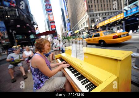 Eine Frau spielt Klavier am Times Square von New York, Montag, 23. Juni 2010. Das Klavier, eines von 60, ist Teil einer Kunstinstallation, die durch die Welt tourt und ihren ersten US-Aufenthalt in New York macht. Das Konzept hat mehr als 130 Klaviere in Parks, Plätzen und Busbahnhöfen in Städten von London bis Sydney, Australien. Foto von Mehdi Taamallah/ABACAPRESS.COM Stockfoto