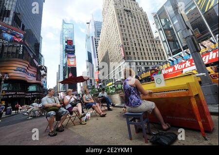 Eine Frau spielt Klavier am Times Square von New York, Montag, 23. Juni 2010. Das Klavier, eines von 60, ist Teil einer Kunstinstallation, die durch die Welt tourt und ihren ersten US-Aufenthalt in New York macht. Das Konzept hat mehr als 130 Klaviere in Parks, Plätzen und Busbahnhöfen in Städten von London bis Sydney, Australien. Foto von Mehdi Taamallah/ABACAPRESS.COM Stockfoto