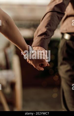Hände des romantischen Paares zu Fuß glücklich zusammen in der Wohnung. Nahaufnahme der Hände zusammenhalten Stockfoto