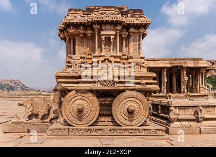 Hampi, Karnataka, Indien - 5. November 2013: Vijaya Vitthala Tempel. Brauner Steinwagen Nahaufnahme unter blauer Wolkenlandschaft. Stockfoto