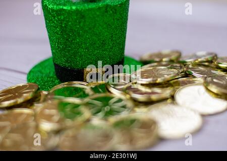 Ein grüner, mit Glitzer bedeckter St. Pattys Day Hut mit Gold Münzen vor ihm Stockfoto