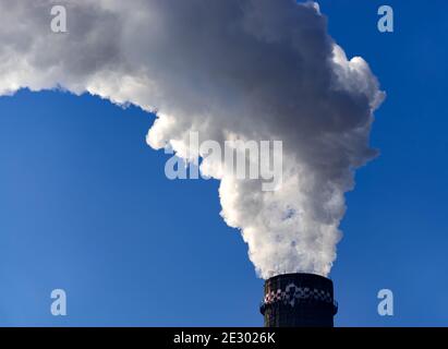 Bukarest, Rumänien - 15. Januar 2021: Kamin des CET Progresul Kraftwerks, verschmutzt mit Rauch durch die Verbrennung von Heizöl und Gasen, in der Sout Stockfoto